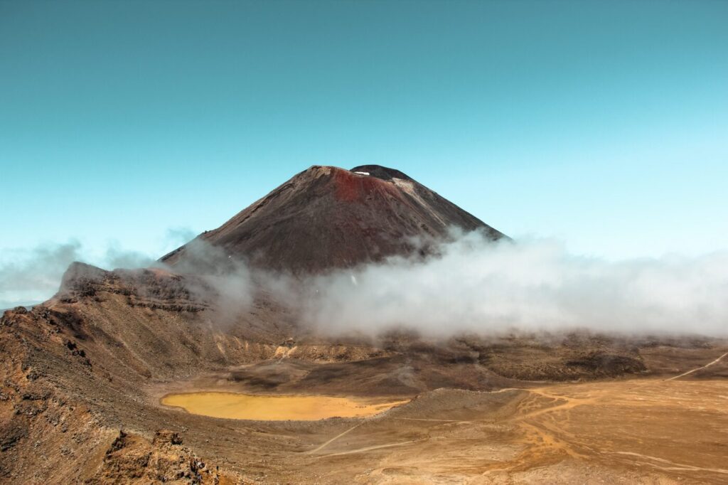Photo of a volcano behind the clouds.