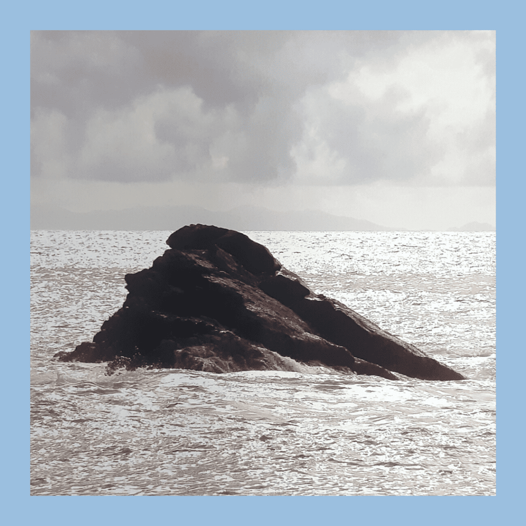Rock on ocean looking like a women